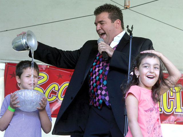Scott with two audience members at a county fair.